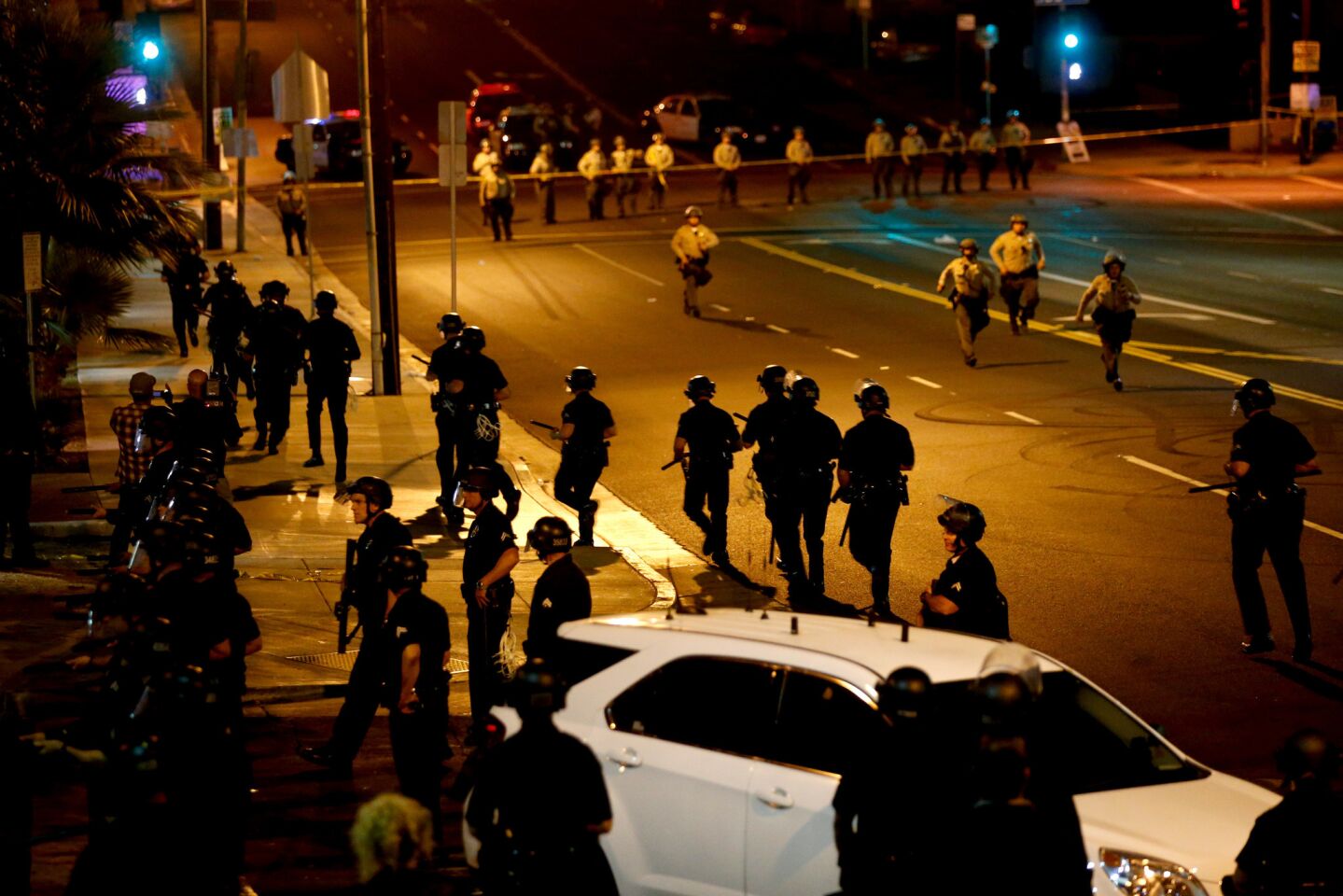Los Angeles police disperse the crowd along Western Avenue and 107th Street in South Los Angeles.