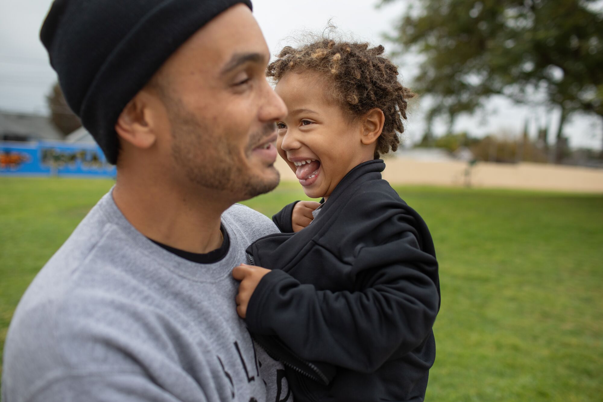 Amanu Brown, 3, laughs with his father, Bobby, at an Inglewood park.