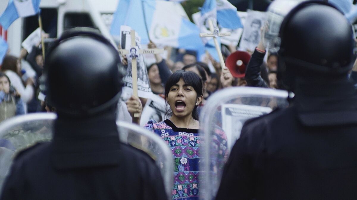 An indigenous protester is flanked by police in a scene from "La Llorona."