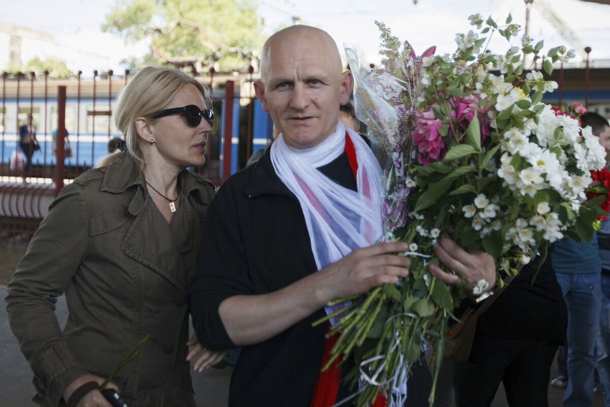 FILE - Belarusian human rights advocate Ales Bialiatski, right, is greeted by his wife Natalya Pinchuk, at a railway terminal in Minsk, Belarus, June 21, 2014. Imprisoned Belarusian human rights campaigner Ales Bialiatski, who shared the Nobel Peace Prize with rights groups in Russia and Ukraine, hasn’t been allowed by Belarus authorities to hand over his speech for the award ceremony, his wife said Thursday, Dec. 8, 2022. (AP Photo/Dmitry Brushko, File)