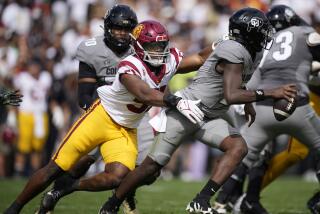 Southern California linebacker Theo Bravos, left, pursues Colorado quarterback Shedeur Sanders.