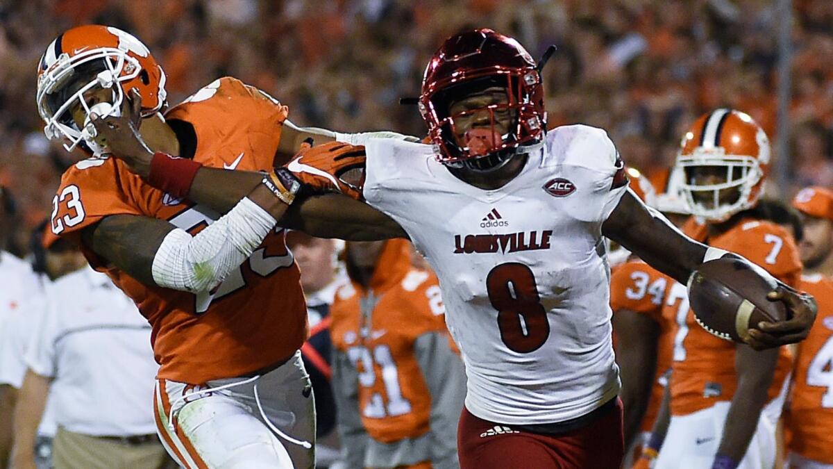 Louisville quarterback Lamar Jackson stiff-arms Clemson safety Van Smith on Oct. 1.