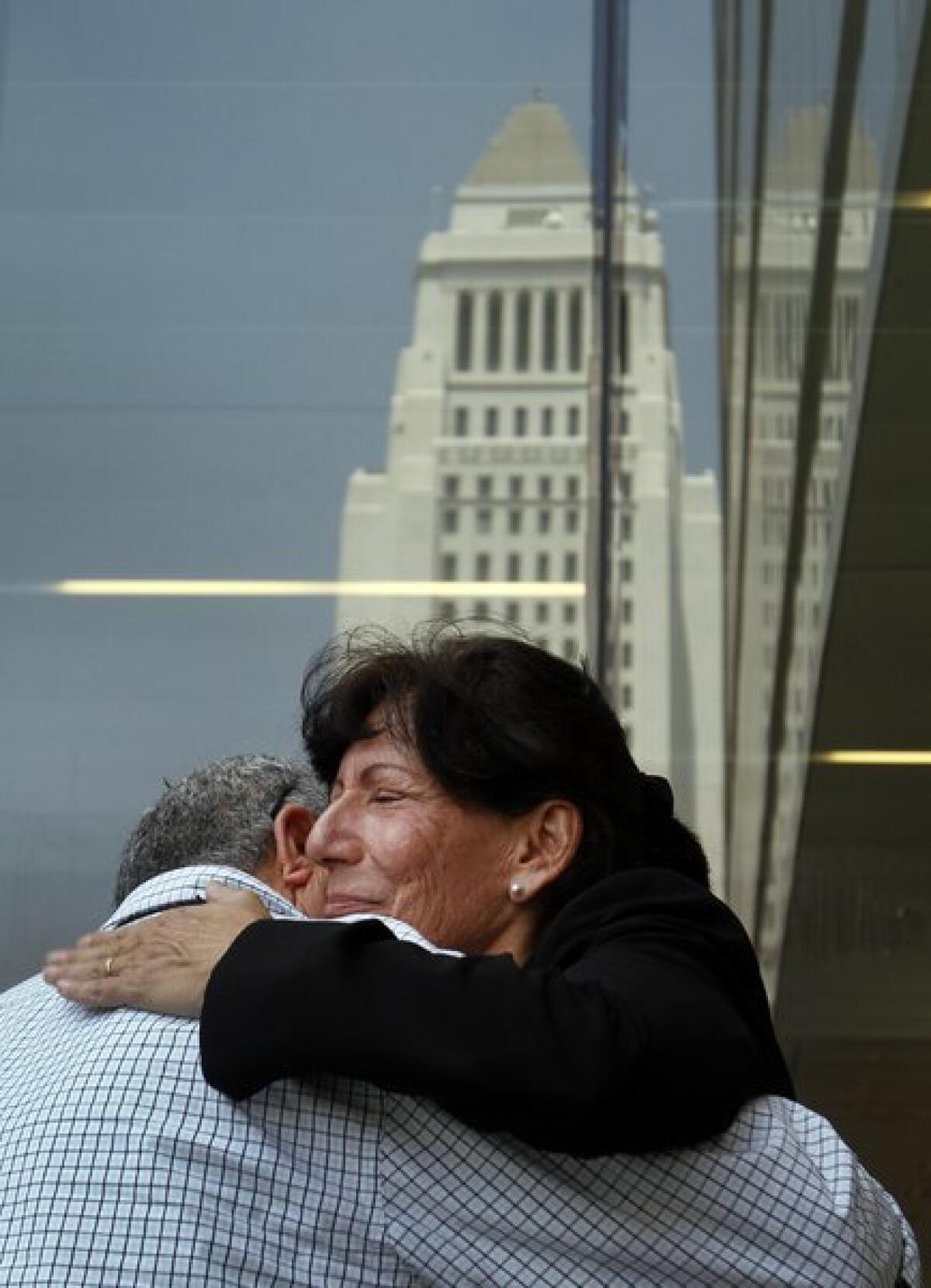 Julie Butcher, mother of victim Matthew Butcher, gets a hug during a news conference at LAPD headquarters on Aug. 5, 2010.