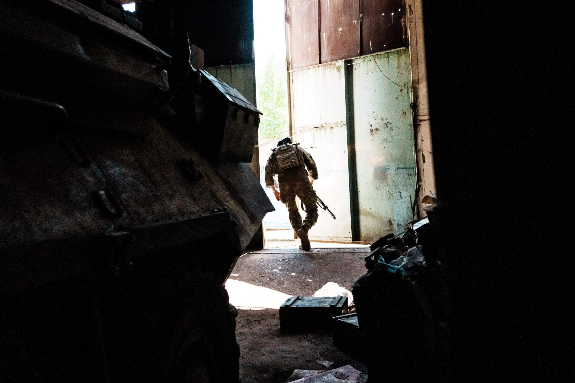 A Ukrainian soldier runs outside from a makeshift military base in Lysychansk, Ukraine.