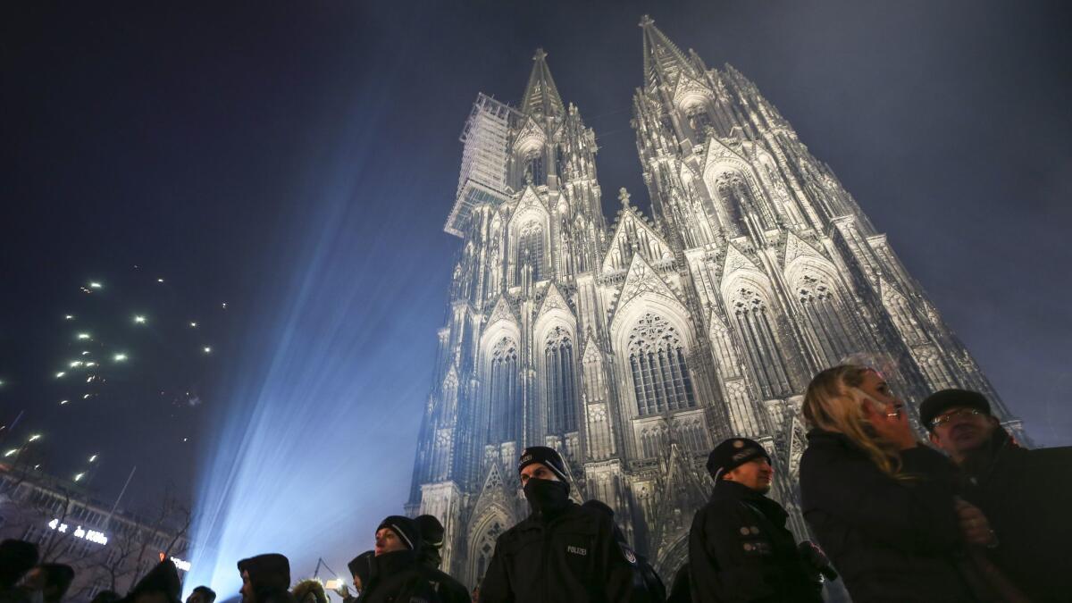 Police stand guard in front of Cologne Cathedral, not far from where hundreds of apparently coordinated sexual assaults were perpetrated on New Year's Eve one year ago.
