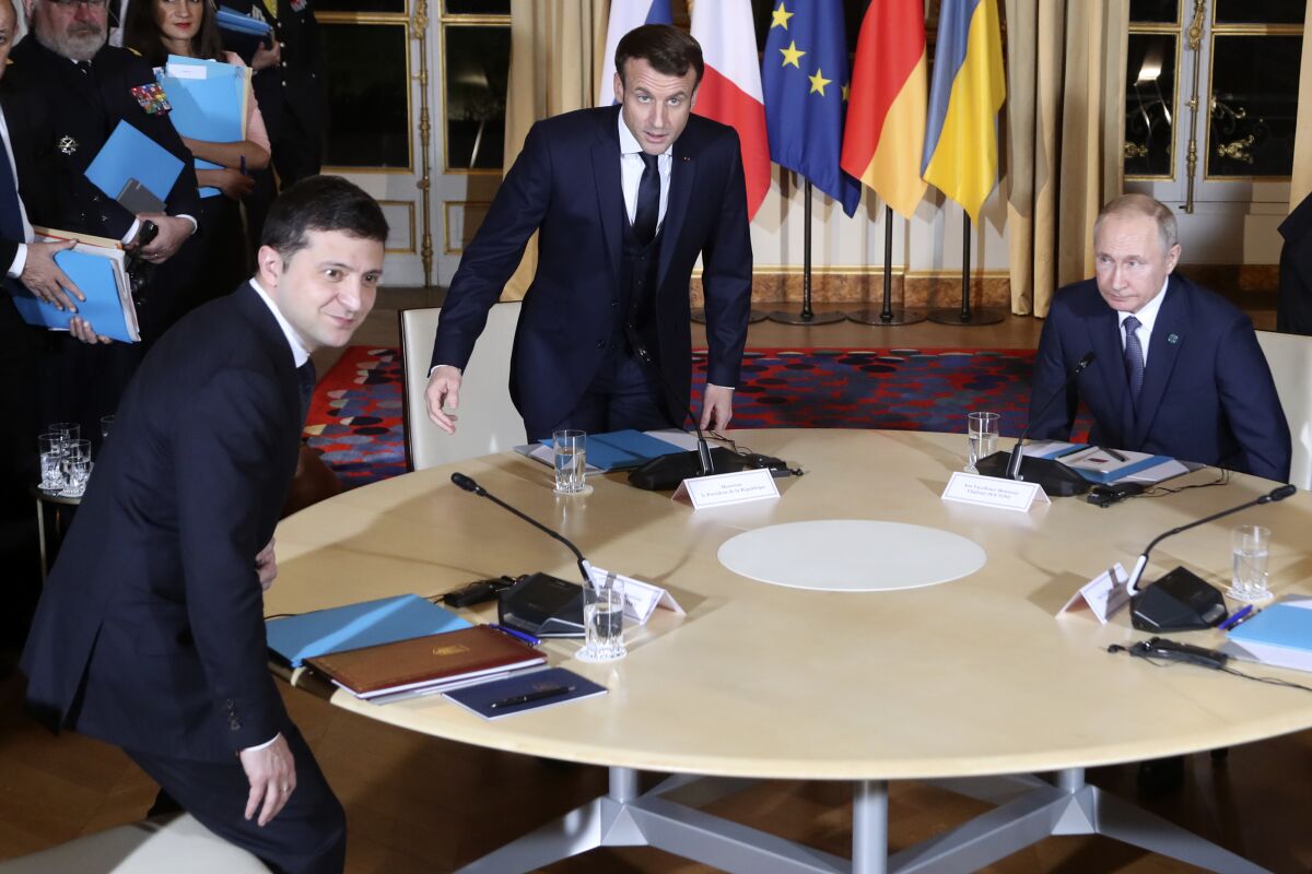 Ukrainian President Volodymyr Zelensky, left, French President Emmanuel Macron, center, and Russian President Vladimir Putin