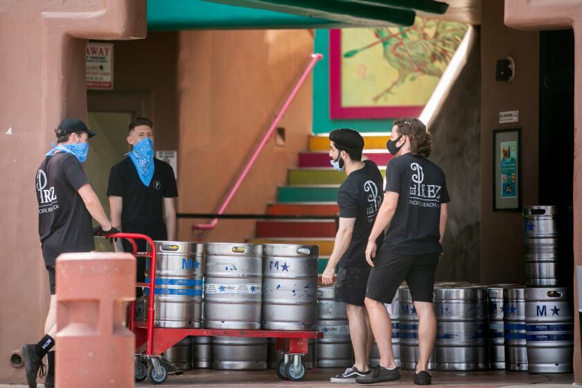 Employees at El Prez move kegs in Pacific Beach ahead of Memorial Day Weekend on May 22, 2020 in San Diego, California. The bar and restaurant was shut down by the county on Friday after images circulated on social media showing a lack of social distancing at the establishment.