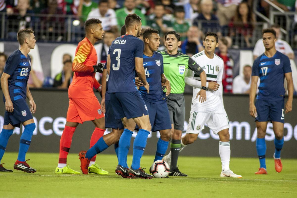 El árbitro Ricardo Montero separa a los jugadores Matt Miazga (c-i) de Estados Unidos y Angel Zaldivar (c-d) de México hoy, martes 11 de septiembre de 2018, durante un juego amistoso entre Estados Unidos y México en el estadio Nissan en Nashville (EE.UU.).