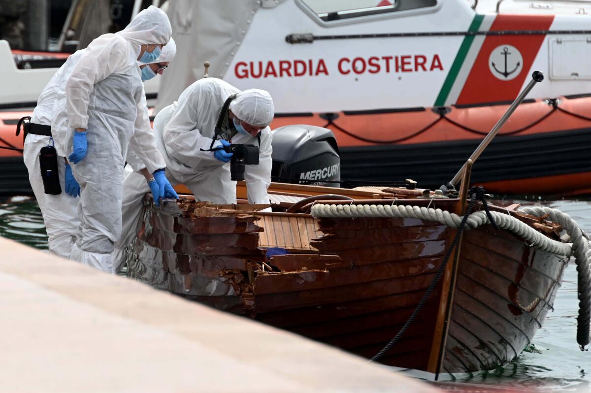 FILE - In this June 21, 2021 file photo, Italian forensic police inspect the damage on a boat as they investigate two German tourists from Munich for a boat collision which killed an Italian man and woman, in Salo', on Lake Garda, northern Italy. Italian authorities say a German man has returned to Italy to surrender himself to police in the criminal probe of a boating accident that killed two Italian boaters last month on Lake Garda. Brescia Prosecutor Francesco Prete told state TV on Monday that besides being investigated for two counts of manslaughter, the suspect is also jailed for failure to help the stricken boaters. (AP Photo/Gabriele Strada, File)