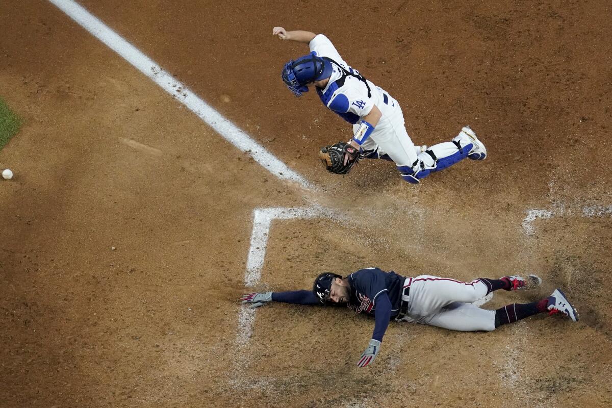 Atlanta's Nick Markakis scores past Dodgers catcher Will Smith on a double by Cristian Pache.