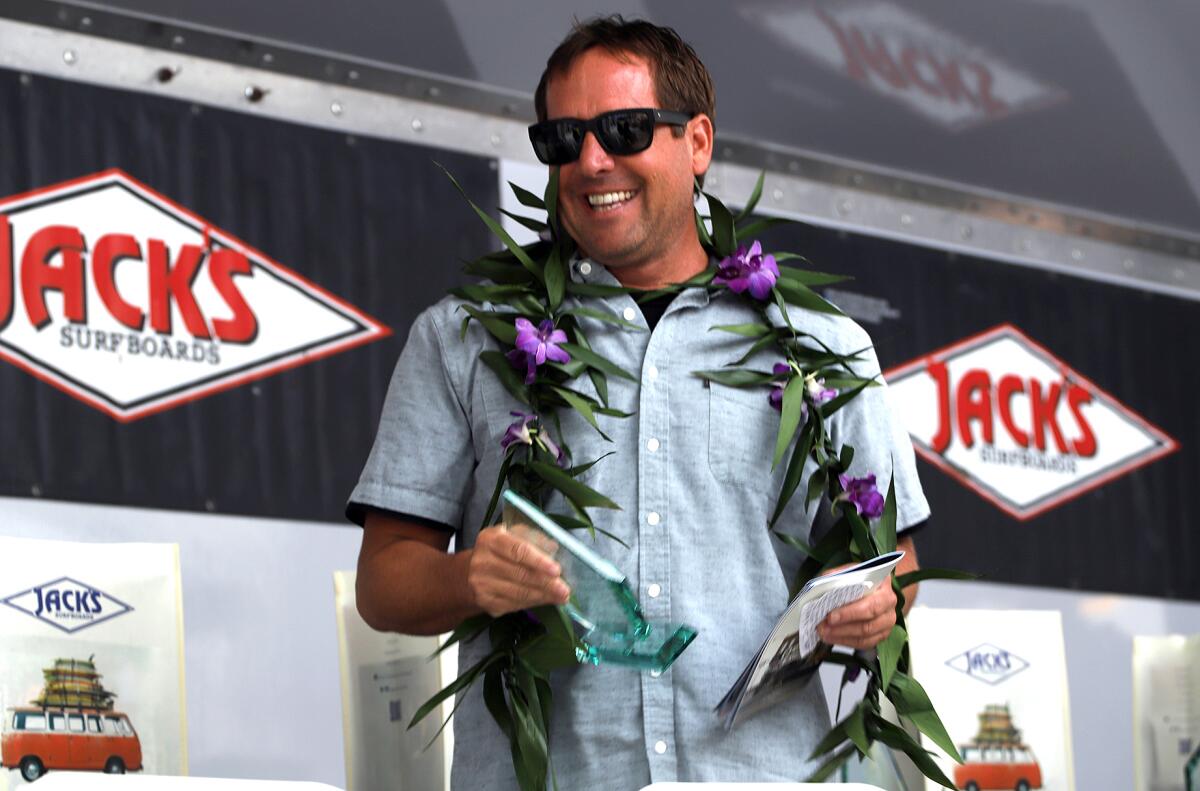 Ryan Turner smiles as he is inducted into the Surfing Walk of Fame in front of Jack's Surfboards on Main Street.