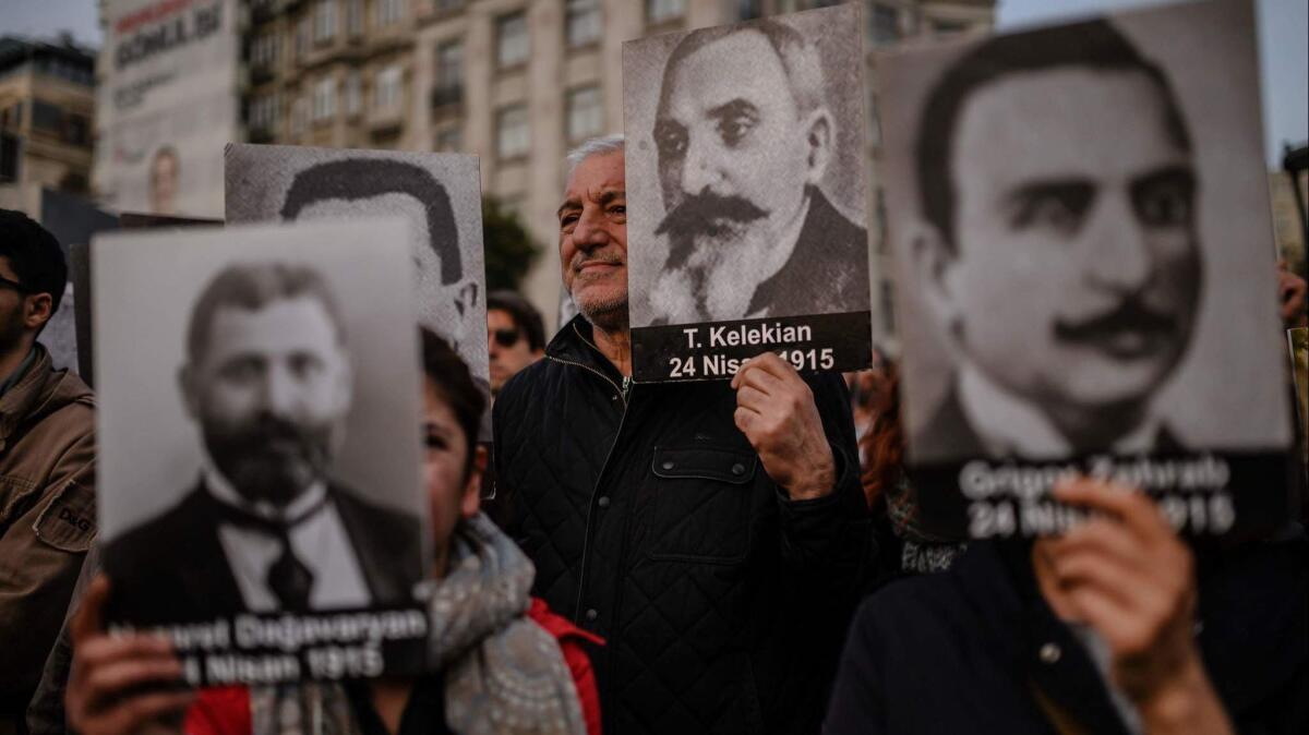 People hold portraits of Armenian intellectuals during a rally held to commemorate the 104th anniversary of the 1915 mass killing of Armenians in the Ottoman Empire in Istanbul on April 24, 2019.