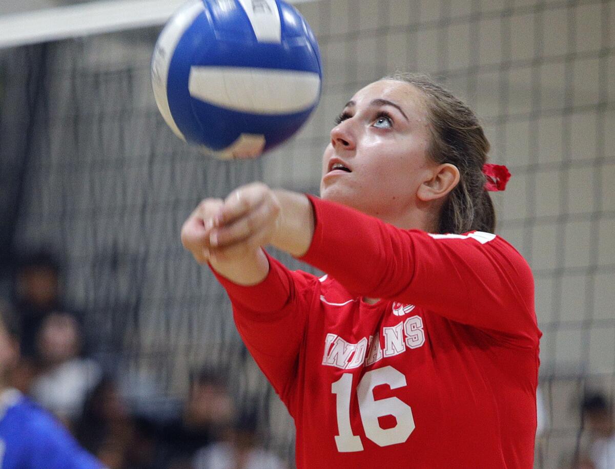 Burroughs High's Milana Abrahamian reaches to the side to keep a ball in play during Tuesday's Pacific League match.