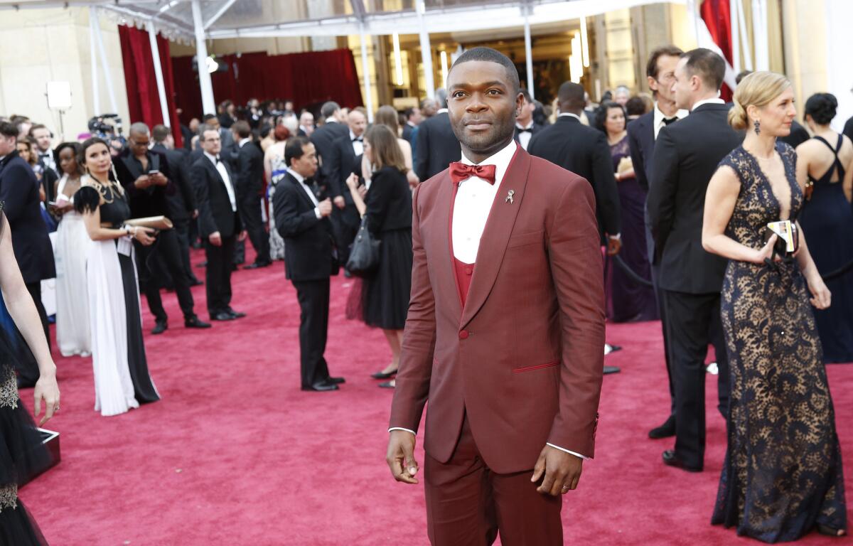David Oyelowo stands out out on the red carpet in a red shawl collar tuxedo with a red silk bow tie and red cummerbund.