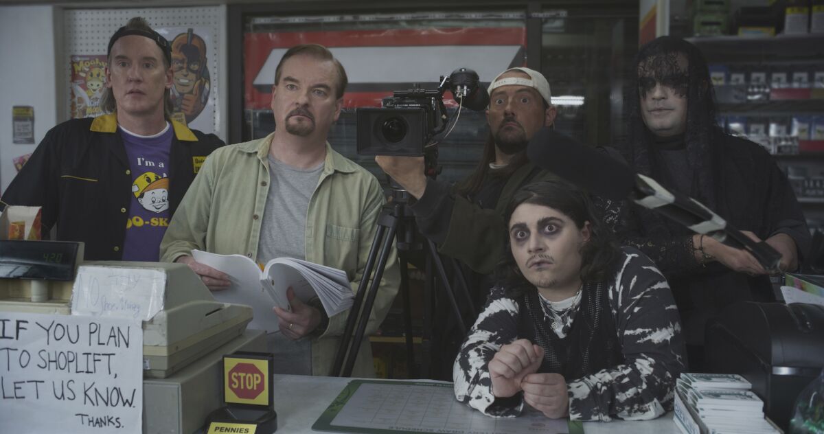 Five men with a video camera behind the counter of a convenience store in the film "Clerks III."