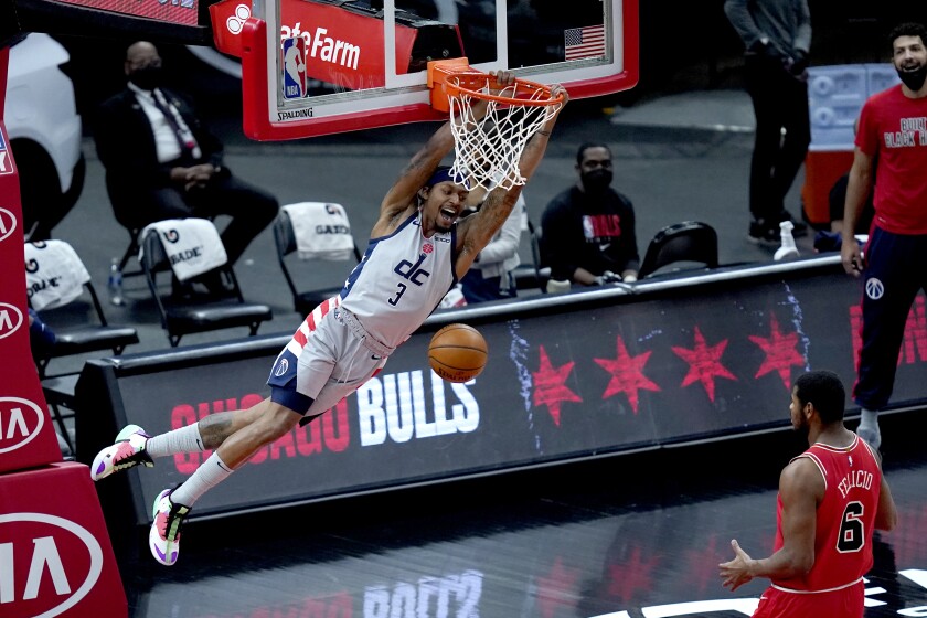 Washington Wizards' Bradley Beal (3) dunks the ball as Chicago Bulls' Cristiano Felicio watches during the first half of an NBA basketball game Monday, Feb. 8, 2021, in Chicago. (AP Photo/Charles Rex Arbogast)