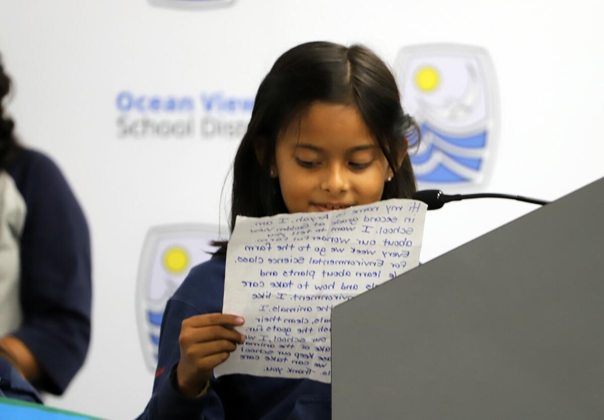 Samantha Tran, a second-grade student from Golden View Elementary, reads a letter.