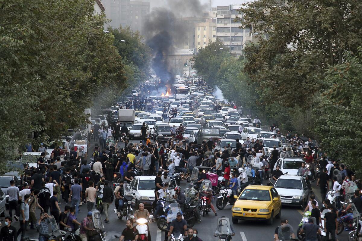 Protesters and cars clogging a street in downtown Tehran