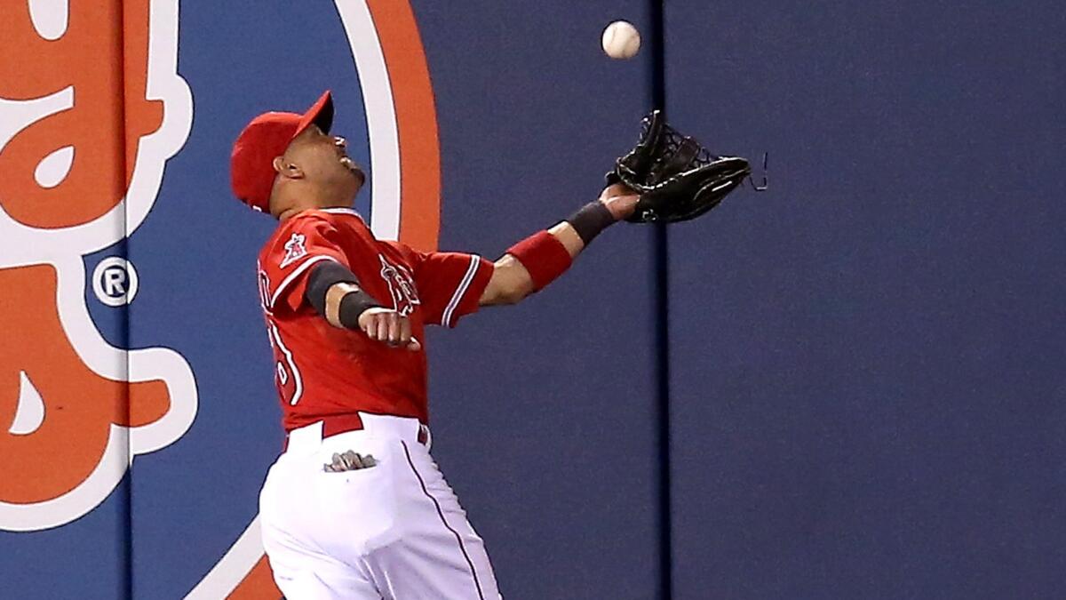 Angels left fielder Shane Victorino tries to track down a deep fly ball by Texas' Shin-Soo Choo, who ended up with a triple in the seventh inning Friday night.