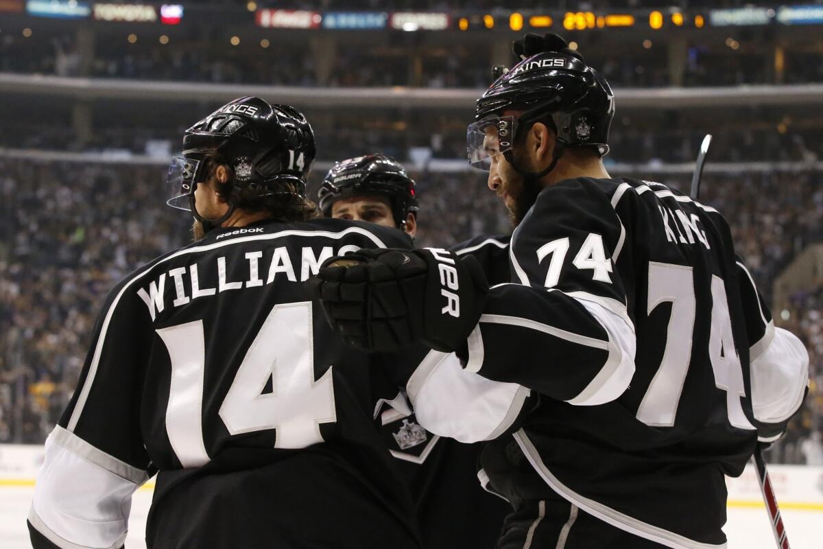 Kings left wing Dwight King (74) is congratulated by teammates Justin Williams and Willie Mitchell after scoring against the Blackhawks in the first period Friday.