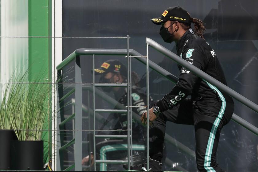Mercedes driver Lewis Hamilton of Britain climbs to the podium after winning the Portugal Formula One Grand Prix at the Algarve International Circuit near Portimao, Portugal, Sunday, May 2, 2021. (AP Photo/Manu Fernandez)