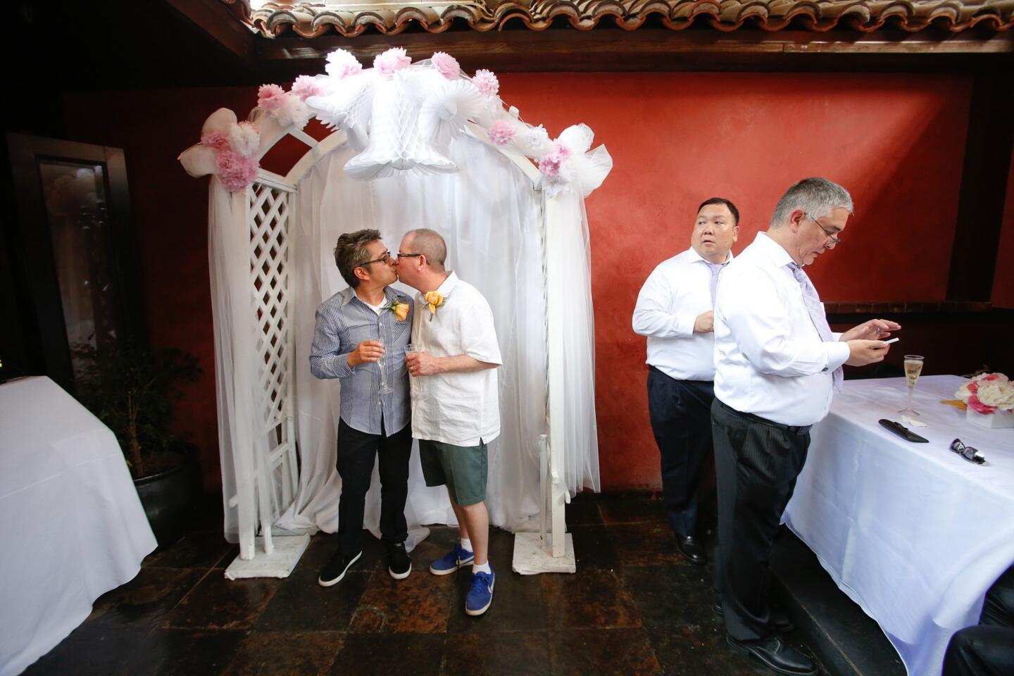 Jaime Ferrar, 54, left and Richard Sage, 52 of North Hollywood share a kiss inside The Abbey Food & Bar in West Hollywood, where a reception was being held for them and all the other gay couples who got married in the nearby auto court outside the West Hollywood City Council Chambers. They have been together for 31 years.