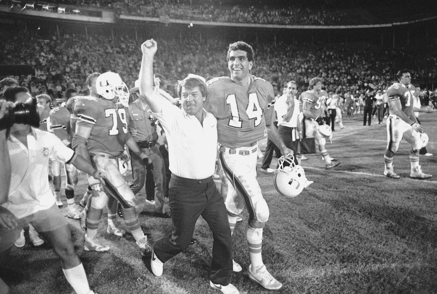 FILE - In this Dec. 2, 1985, file photo, University of Miami football coach Jimmy Johnson leaves the field with quarterback Vinny Testaverde after the Hurricanes defeated Notre Dame, 58-7 in Miami. Testaverde, Danny Wuerffel, Tommie Frazier, Ron Dayne and Orlando Pace headline the latest class getting enshrined in the College Football Hall of Fame. (AP Photo/Ray Fairall, File)