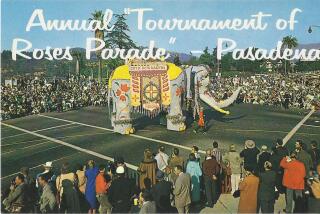 An elephant float comes around a corner at the Rose Parade