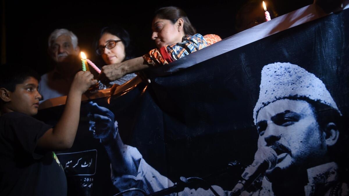 Pakistani activists light candles in Karachi as thousands crowd the streets for the funeral of Sufi musician Amjad Sabri, who was gunned down in what police called an "act of terror."