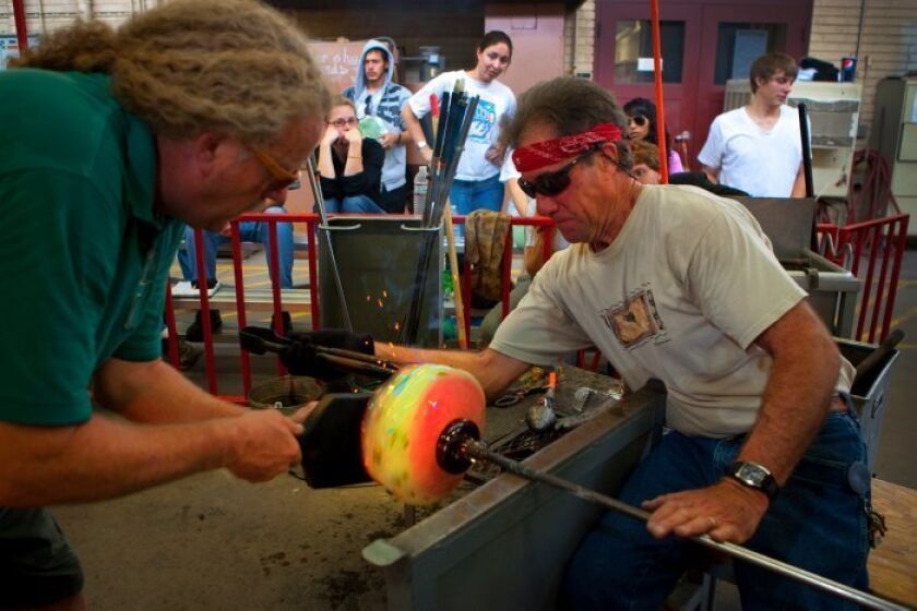 Garry Cohen shapes glass with the help of John Puroy, assistant lab tech. “It’s kind of like surfing or skateboarding,” said one student. “It’s just you and the glass.”