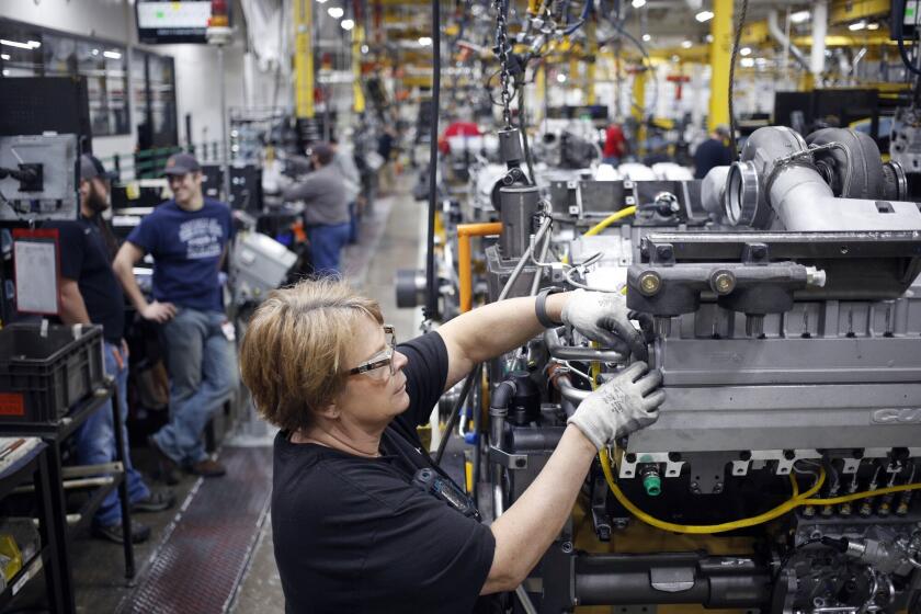 A worker assembles components on a diesel engine at an engine plant in Seymour, Indiana.