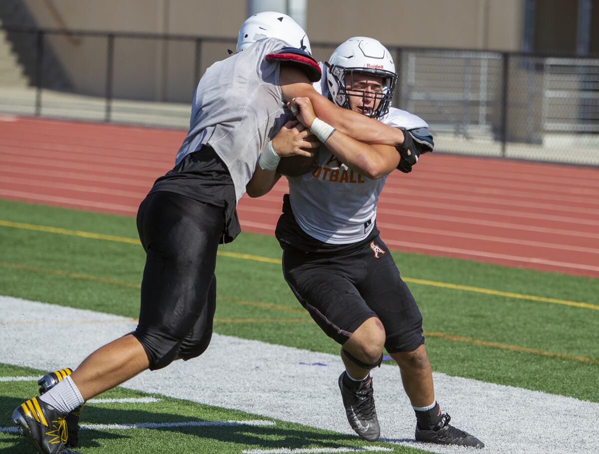 Huntington Beach's Jacob Sanden, left, and Brandon Bova work on drills during a practice at Cap Sheue Field on Aug. 7.