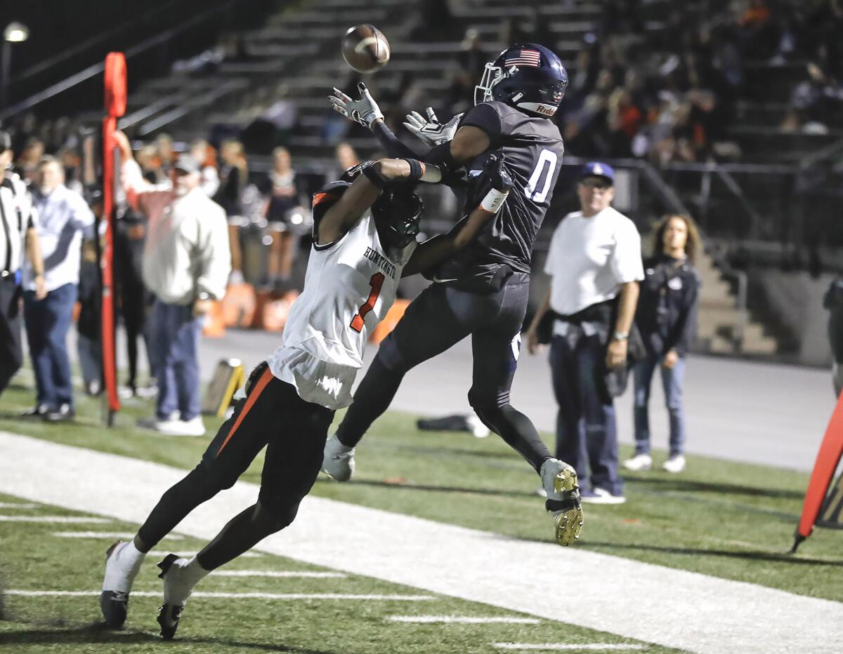 Newport Harbor's Jordan Anderson leaps over Huntington Beach's Haston Allen for a touchdown catch during Friday's game.
