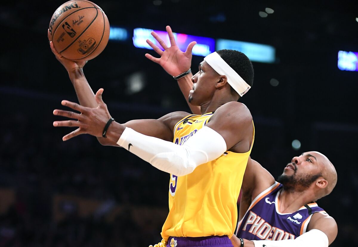 The Lakers' Rajon Rondo beats the Suns' Jevon Carter to score a basket in the third quarter at Staples Center on Monday.