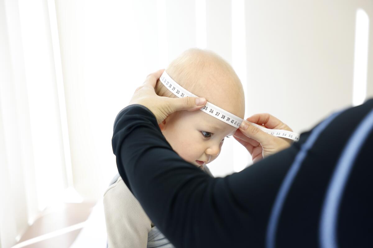 Noah, who is 9 months old, has his measurements taken by medical assistant Shellee Rayl.