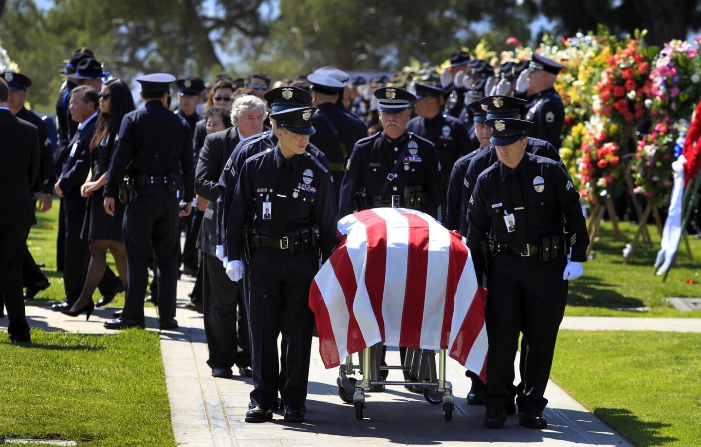 LAPD officers carry the casket of colleague Nicholas Lee during a graveside service in Glendale.