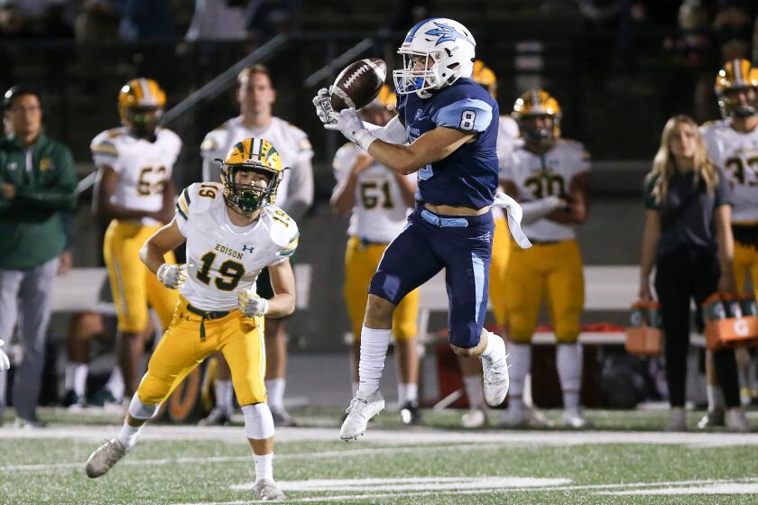 Corona del Mar's Ryder Haupt (8) intercepts a pass intended for Edisons Troy Fletcher (19) in a Sunset League football game on Friday night.