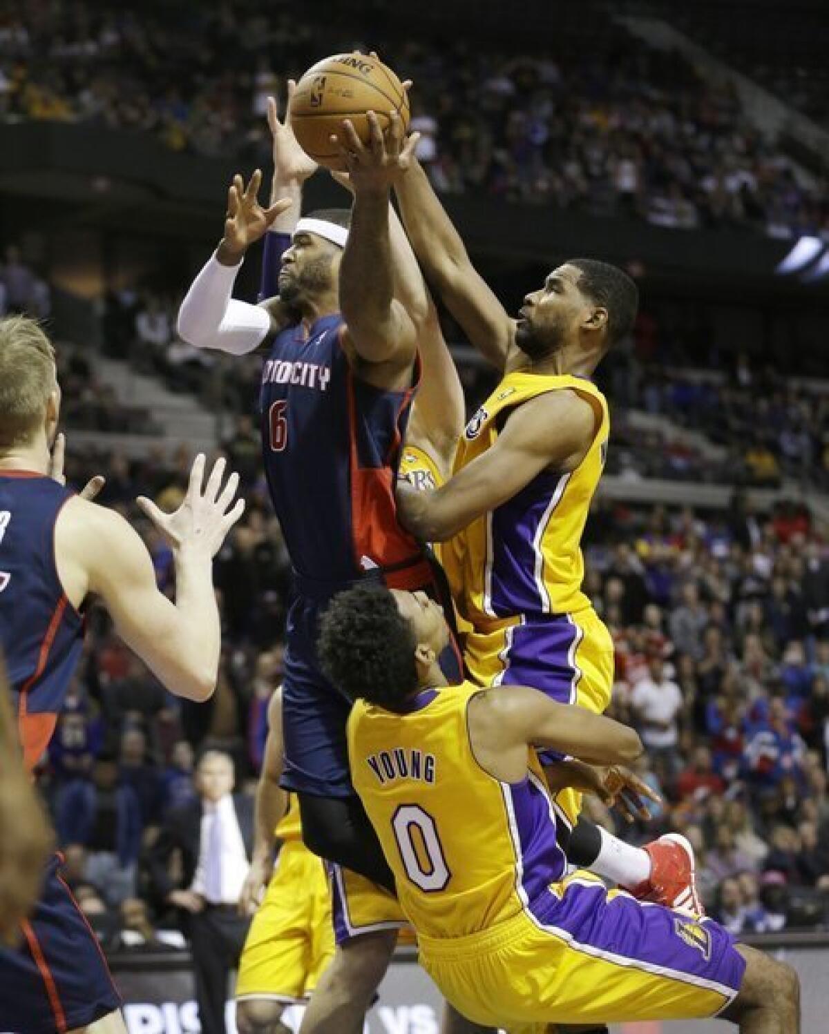 The Lakers' Nick Young takes a charge from Josh Smith in the closing seconds of a game against the Detroit Pistons.