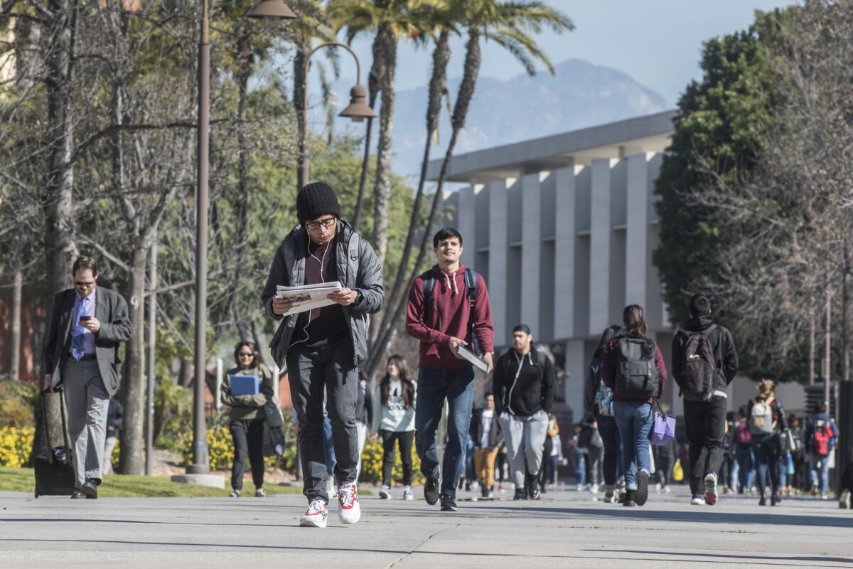 Cal State Los Angeles students walk across campus. University officials are considering a plan to reduce the incoming class by 600 students and raise requirements for GPA and standardized test scores for fall 2020.