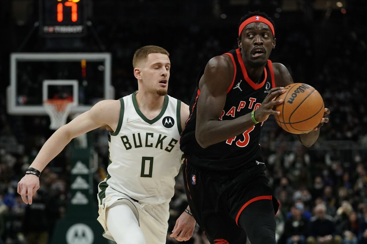 Toronto Raptors' Pascal Siakam drivers past Milwaukee Bucks' Donte DiVincenzo during the first half of an NBA basketball game Saturday, Jan. 15, 2022, in Milwaukee. (AP Photo/Morry Gash)