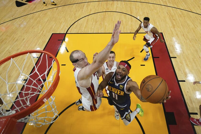 Denver Nuggets forward Bruce Brown (11) drives to the basket Miami Heat center Cody Zeller (44) defends during the first half in Game 4 of of the basketball NBA Finals, Friday, June 9, 2023, in Miami.(Kyle Terada-USA Today Sports via AP) Mandatory credit