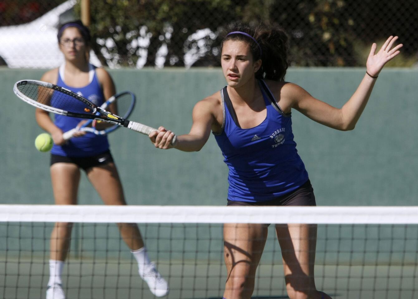 Burbank High School doubles player Elizabeth Sanchez returns one as teammate Meredy Gharabegi looks on in the background during Pacific League tennis playoff game at Pasadena High School in Pasadena on Wednesday, Oct. 30, 2013.