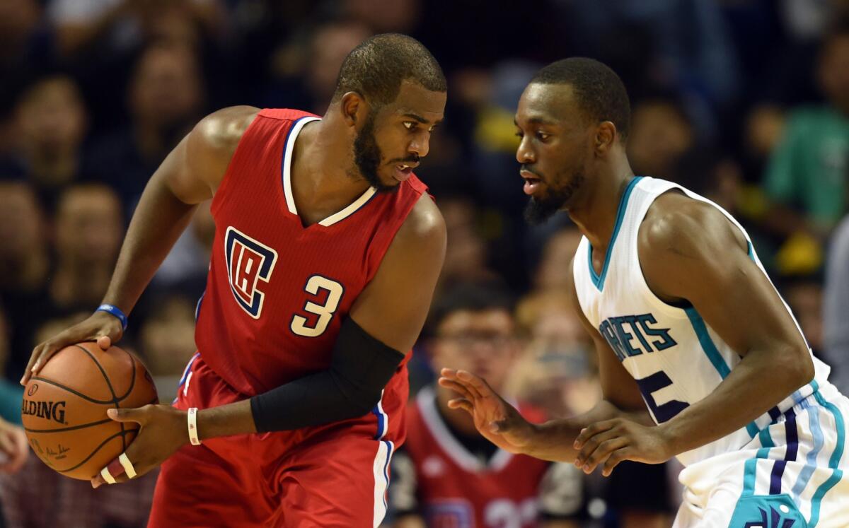 Clippers guard Chris Paul is defended by Kemba Walker of the Charlotte Hornets during a preseason game in China on Oct. 14.