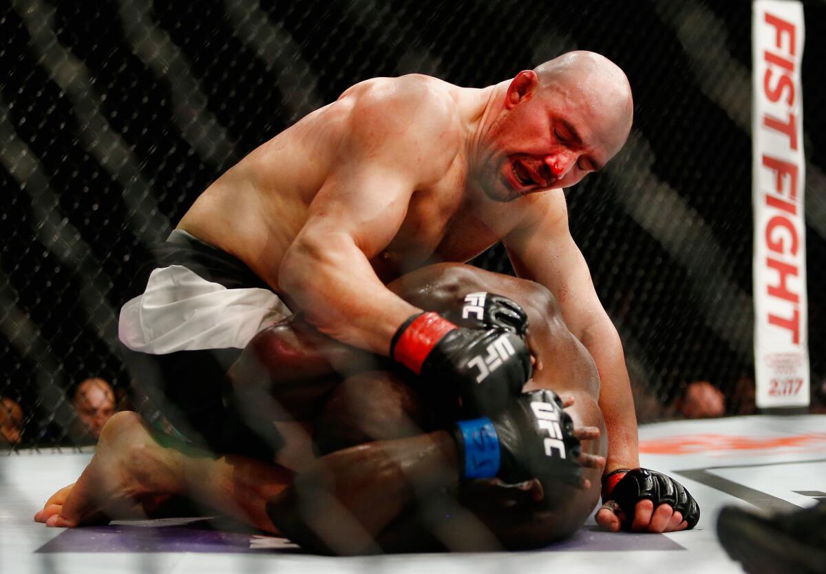 Glover Teixeira hammers Jared Cannonier as he protects himself during their light-heavyweight bout at UFC 208.