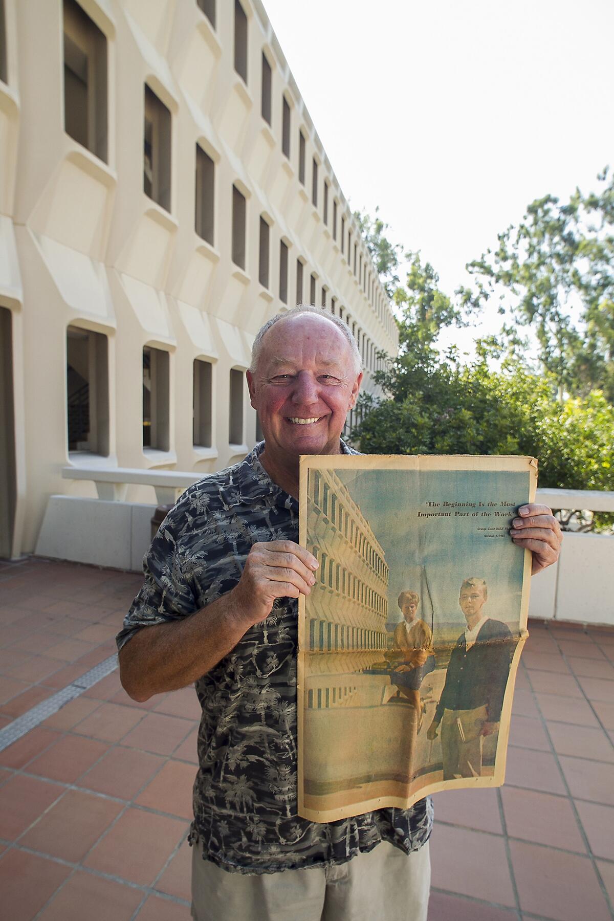 Mike Grayston holds a copy of the 1965 Daily Pilot that featured him on his first day at UCI when it opened.