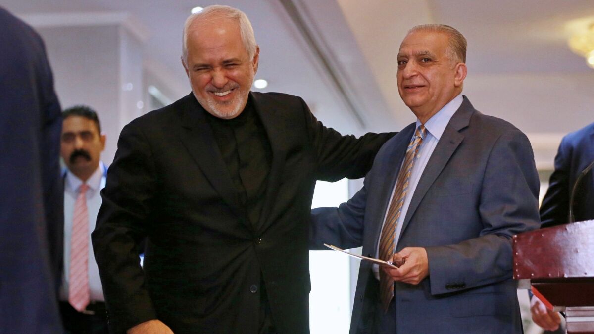 Iraqi Foreign Minister Mohammed Hakim, right, talks with his Iranian counterpart Mohammad Javad Zarif, after their news conference at the Ministry of Foreign Affairs in Baghdad on Sunday.