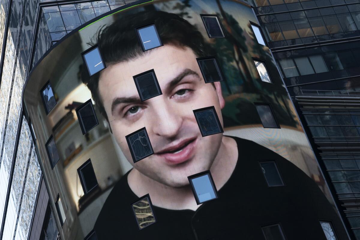 Brian Chesky, CEO of Airbnb, is shown on an electronic screen at the Nasdaq MarketSite in New York. 