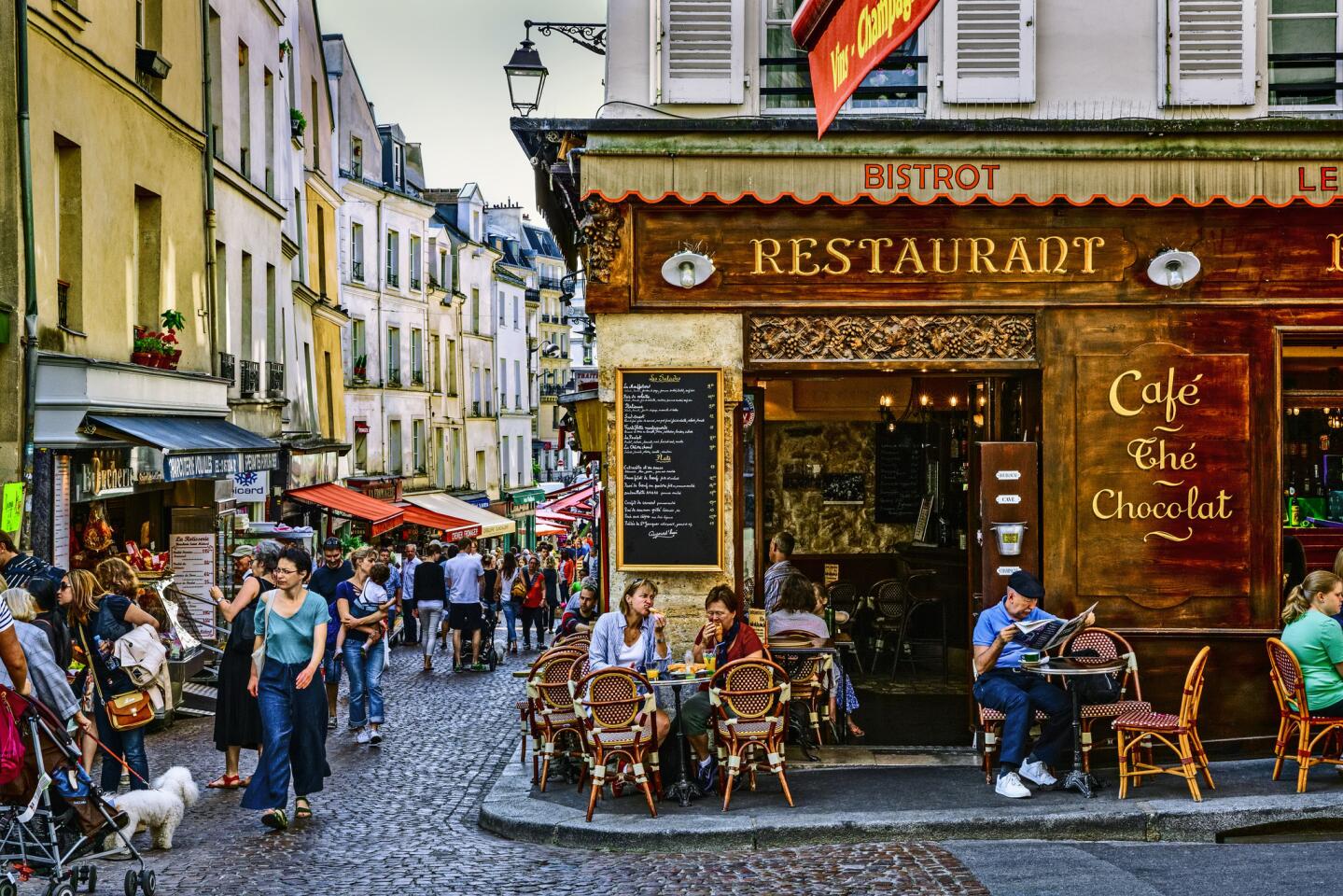 Shops and bistros in Mouffetard Street, Paris. The best way to explore the city's arrondissements is on foot. Just don't wear sneakers.