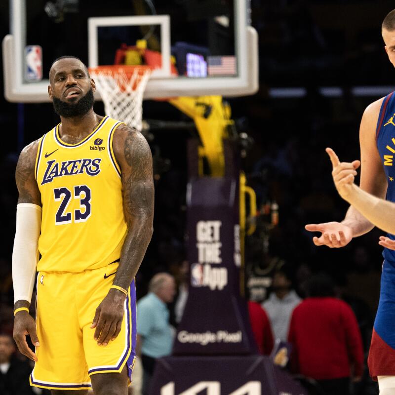 Lakers forward LeBron James looks over as Nuggets center Nikola Jokic chats with the ref 