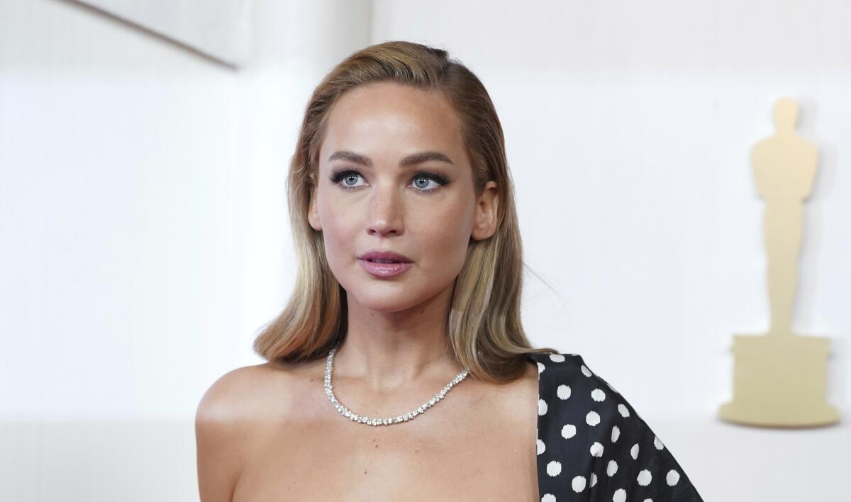 Jennifer Lawrence wears a diamond necklace and one-shoulder polka dot gown